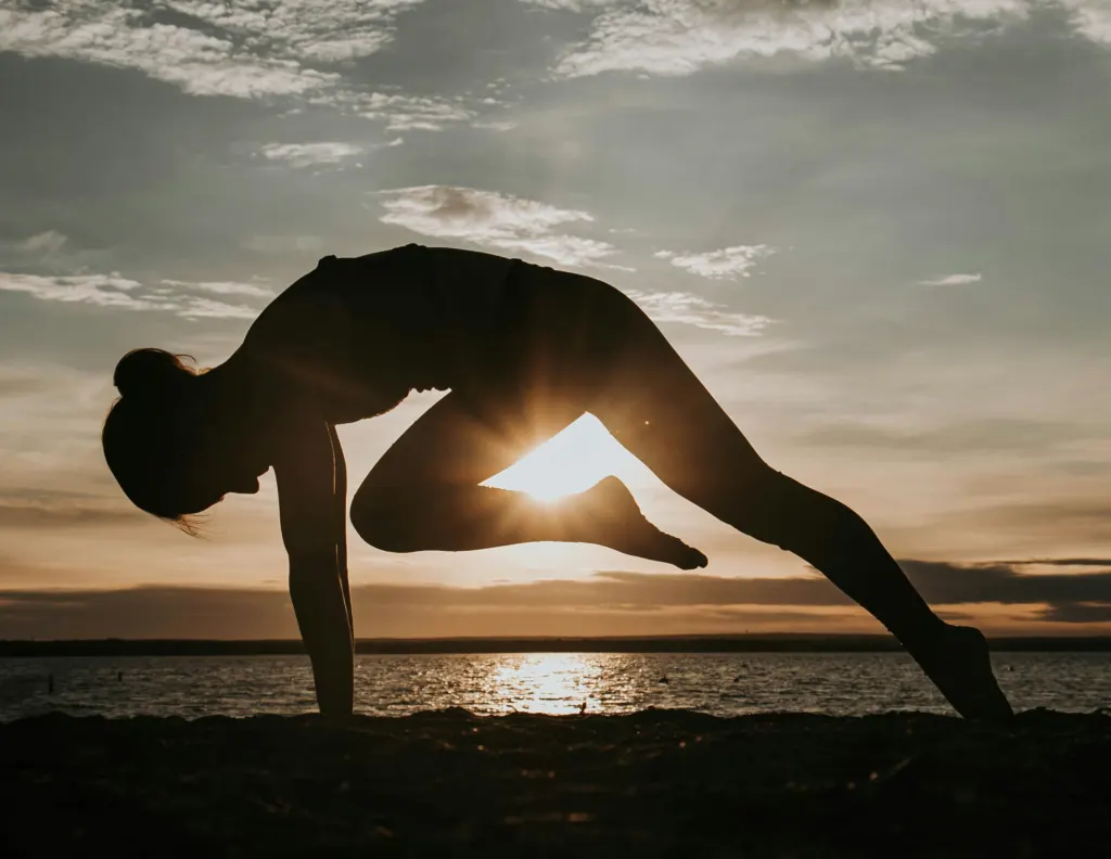 Posture de yoga en silhouette au coucher du soleil