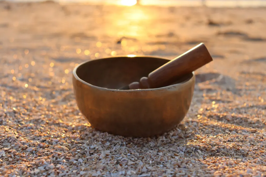 Bol chantant posé sur le sable au soleil couchant
